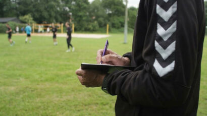 Eine Person, die auf einem Klemmbrett schreibt.